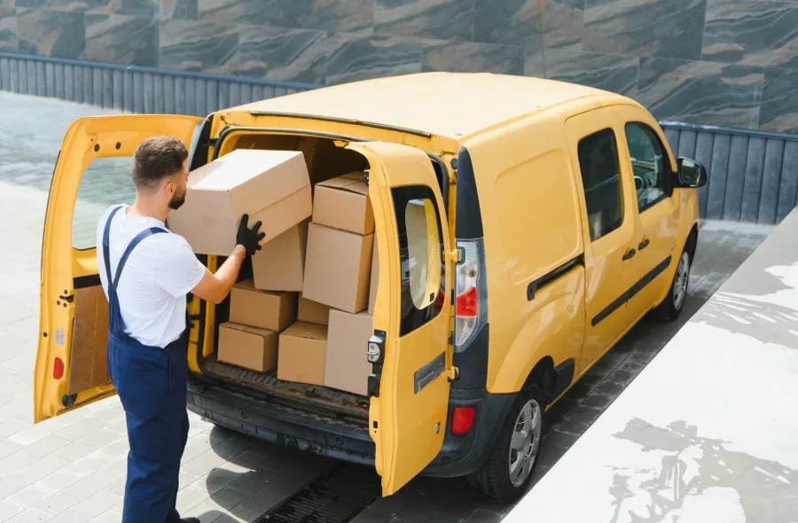 Repartidor cargando cajas en una camioneta de reparto