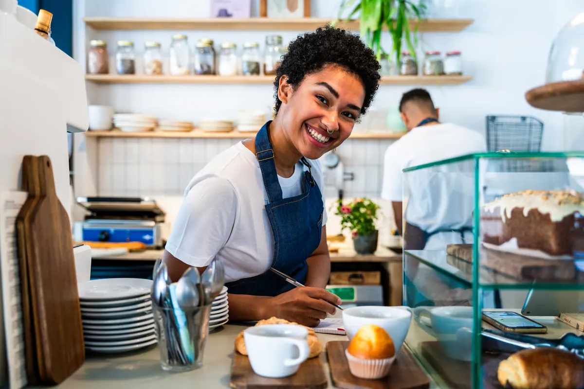 Empleado de una cafetería junto a la vitrina